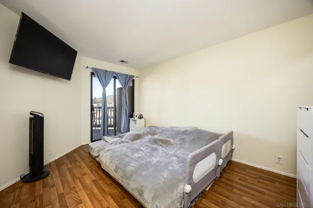 a spacious bedroom with a bed and a flat screen tv