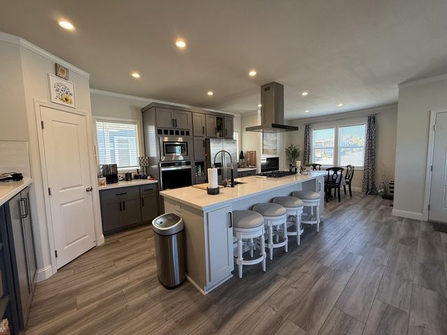 a kitchen with a sink a counter top space stainless steel appliances and cabinets
