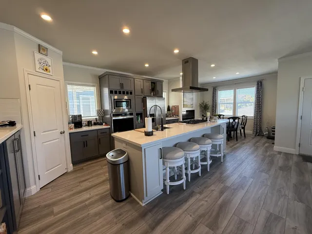 a kitchen with a sink a counter top space stainless steel appliances and cabinets