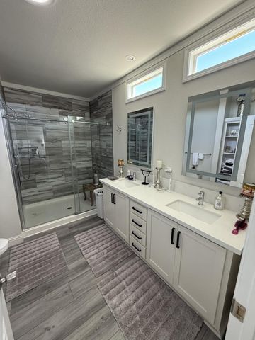 a large bathroom with a double vanity sink a mirror and a shower