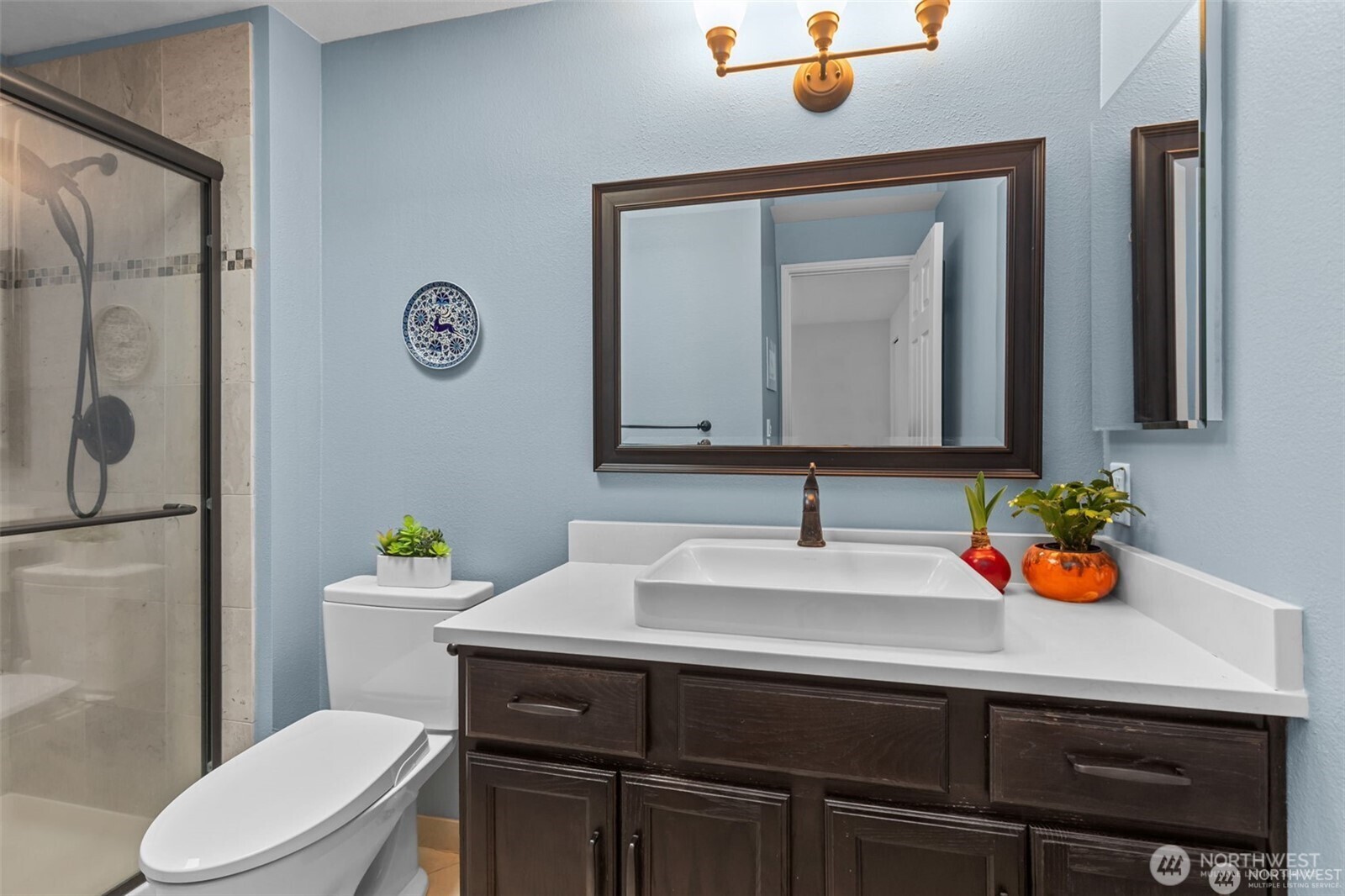 4222 Beach Drive Southwest, Unit 303 Seattle, WA 98116 - Photo 18 of 25 a bathroom with a sink vanity mirror and toilet