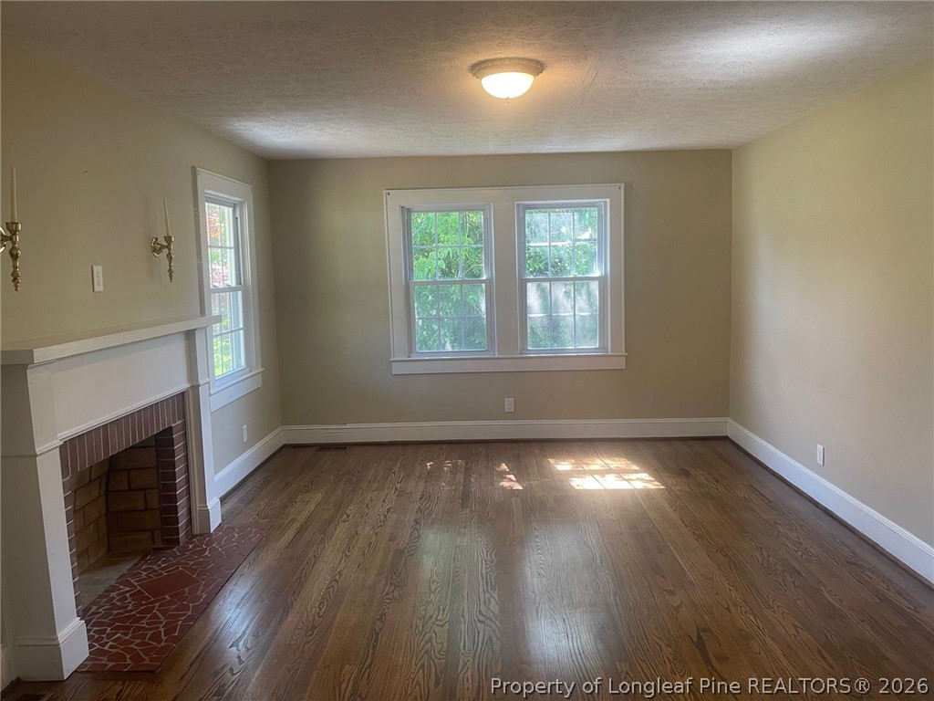 2515 Fort Bragg Road Fayetteville, NC 28303 - Photo 10 of 23 an empty room with wooden floor fireplace and windows