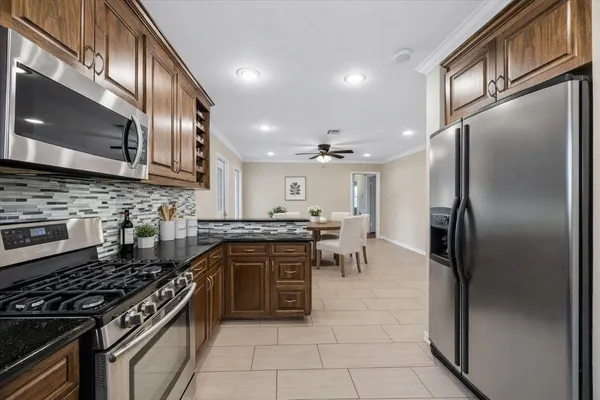 a kitchen with stainless steel appliances granite countertop a stove a refrigerator and a microwave