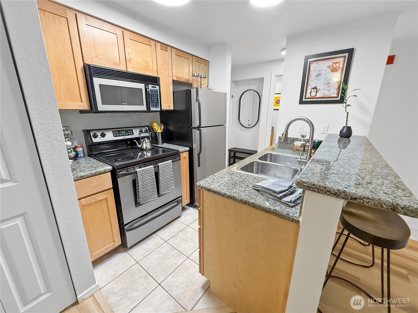 300 10th Avenue, Unit B105 Seattle, WA 98122 - Photo 17 of 40 a kitchen with stainless steel appliances granite countertop a stove top oven a sink dishwasher and a microwave