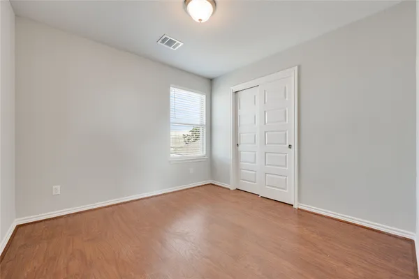 an empty room with windows and closet