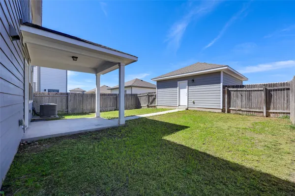 a view of a backyard with a tub and wooden fence