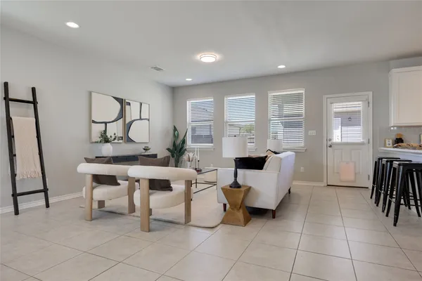 a living room with furniture a flat screen tv and a window
