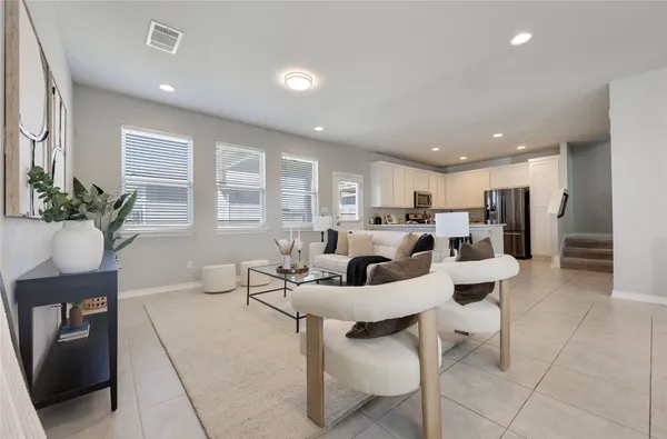a living room with furniture a dining table and a potted plant