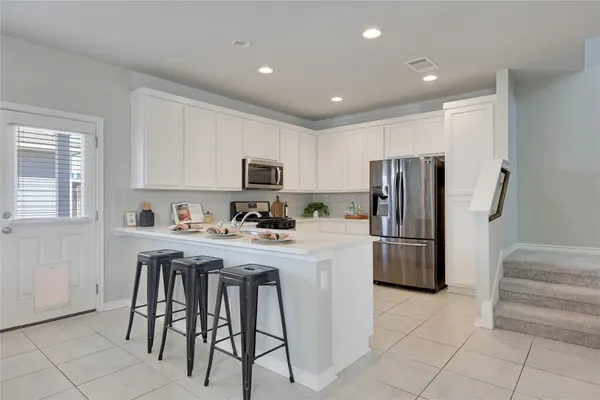 a kitchen with stainless steel appliances a refrigerator stove microwave and cabinets