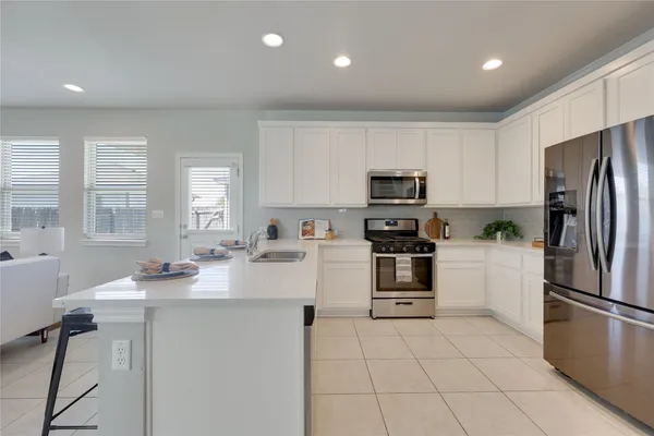 a kitchen with a sink stainless steel appliances and white cabinets