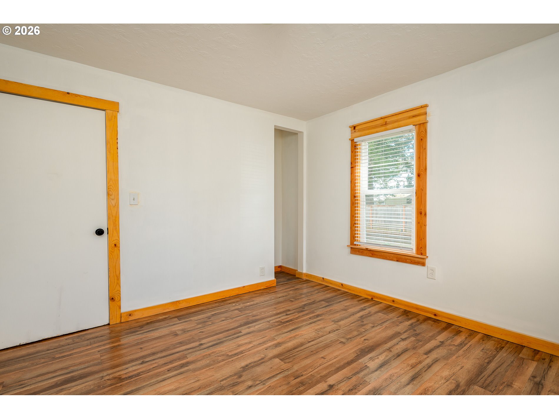 1520 North Maple Street Canby, OR 97013 - Photo 16 of 46 a view of an empty room with wooden floor and a window