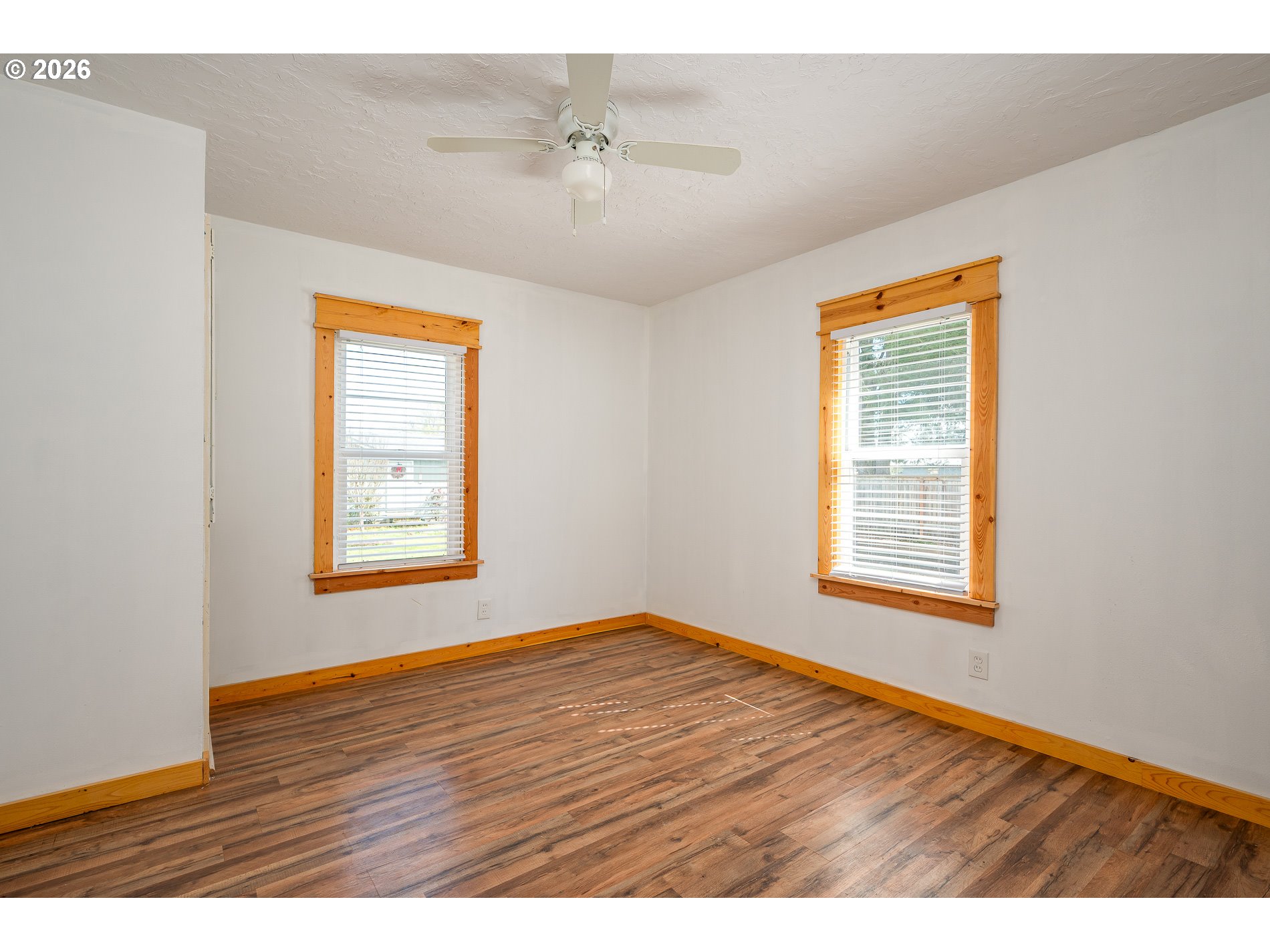 1520 North Maple Street Canby, OR 97013 - Photo 20 of 46 a view of an empty room with wooden floor and a window
