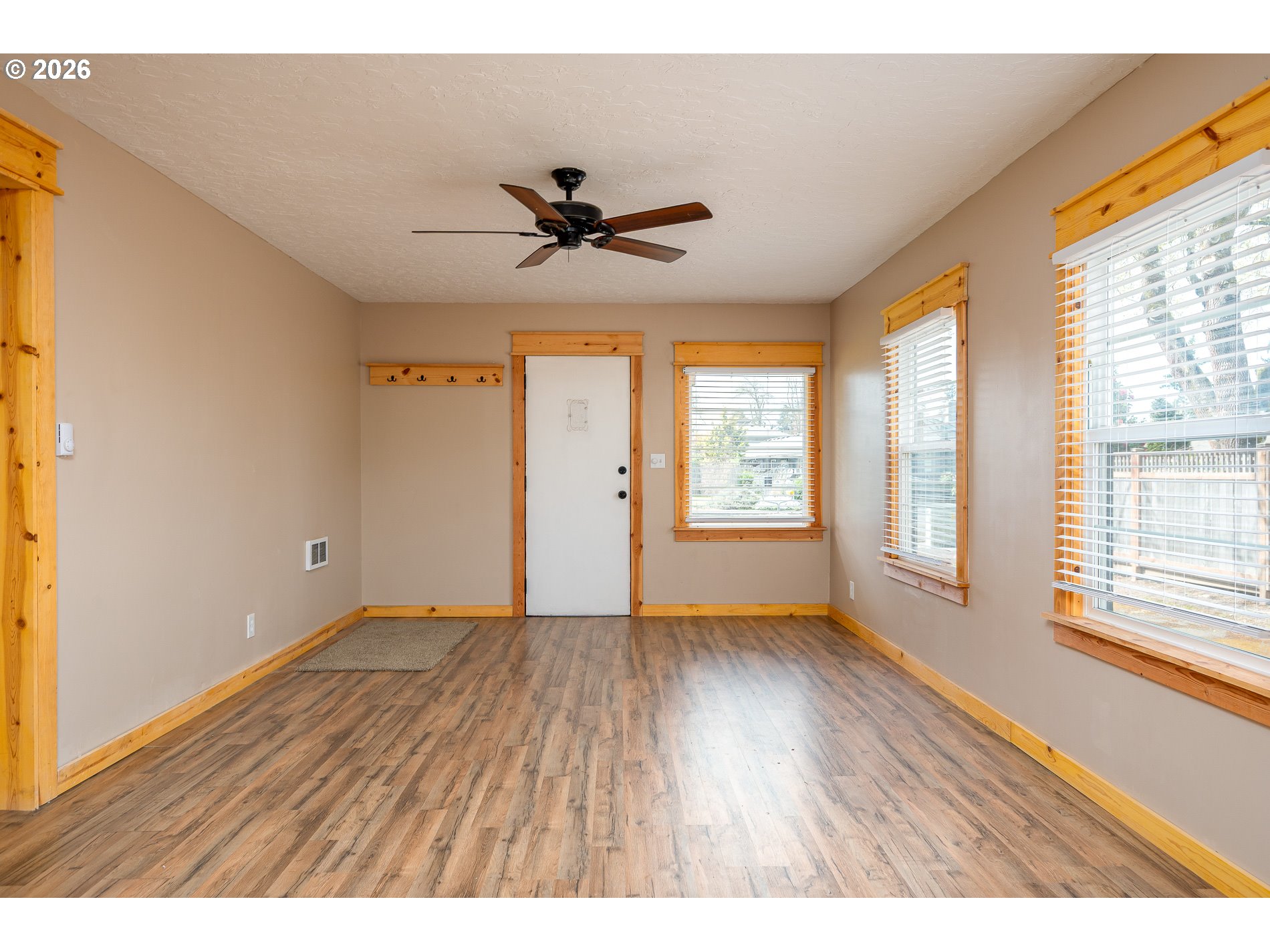 1520 North Maple Street Canby, OR 97013 - Photo 8 of 46 a view of an empty room with a window and wooden floor