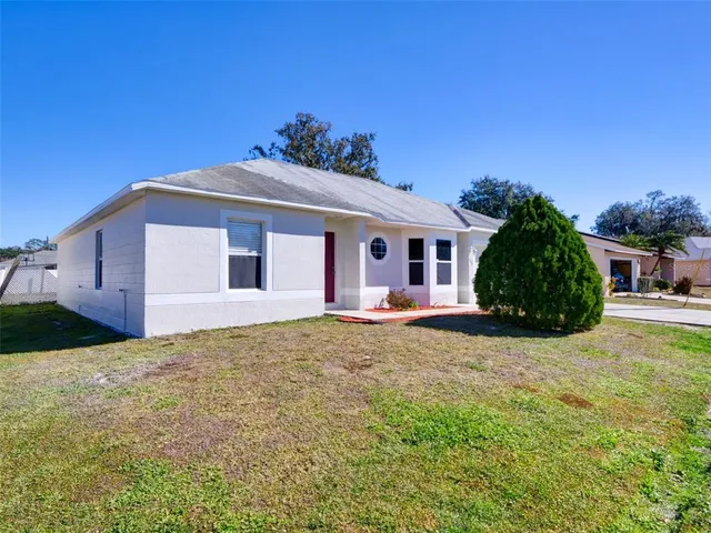 a view of a house with backyard and tree