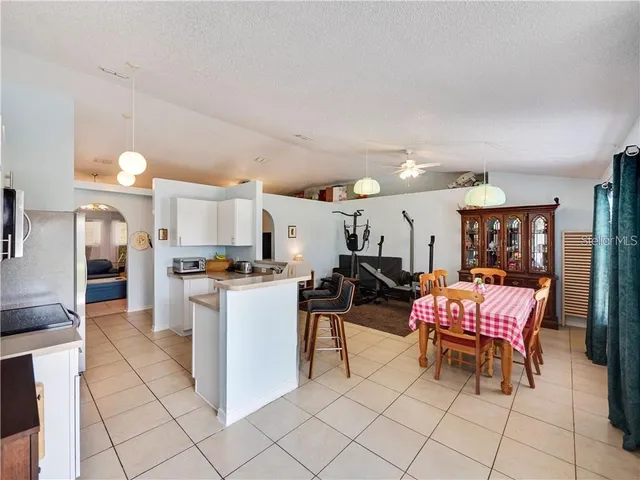 a kitchen with a dining table chairs and a refrigerator