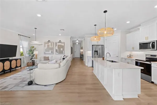a living room with furniture a flat screen tv and kitchen view