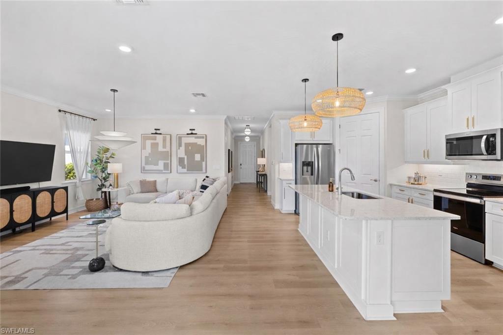 488 Polihale Way Naples, FL 34114 - Photo 12 of 49 a living room with furniture a flat screen tv and kitchen view