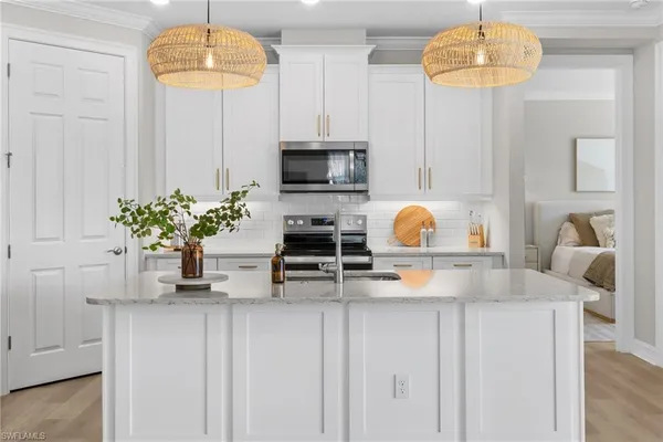 a kitchen with stainless steel appliances granite countertop a sink and a white cabinets