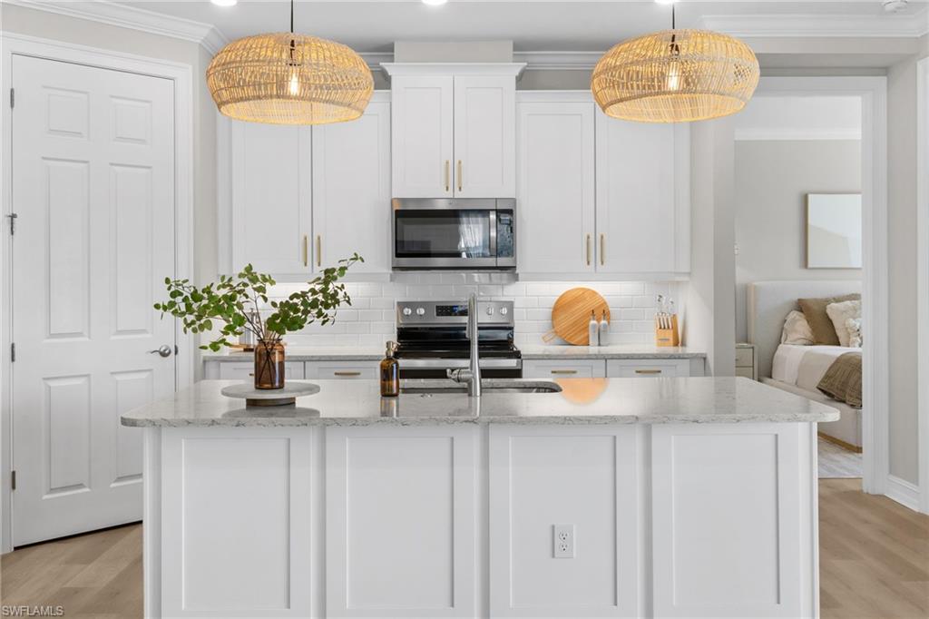 488 Polihale Way Naples, FL 34114 - Photo 14 of 49 a kitchen with stainless steel appliances granite countertop a sink and a white cabinets
