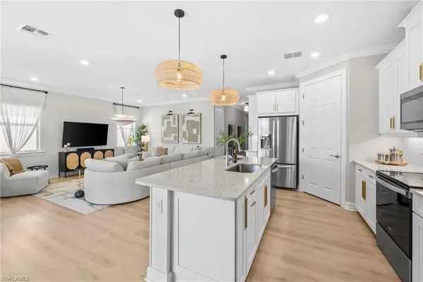 a large kitchen with stainless steel appliances lots of counter space and windows