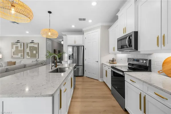 a kitchen with stainless steel appliances granite countertop a sink a stove and a wooden floors