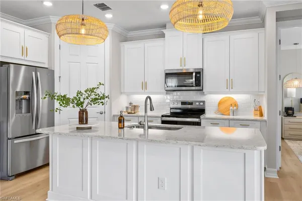 a kitchen with stainless steel appliances granite countertop a refrigerator a stove a microwave and a refrigerator