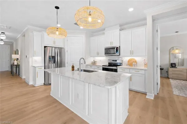 a kitchen with stainless steel appliances a refrigerator a stove a sink dishwasher and a fireplace with wooden floor