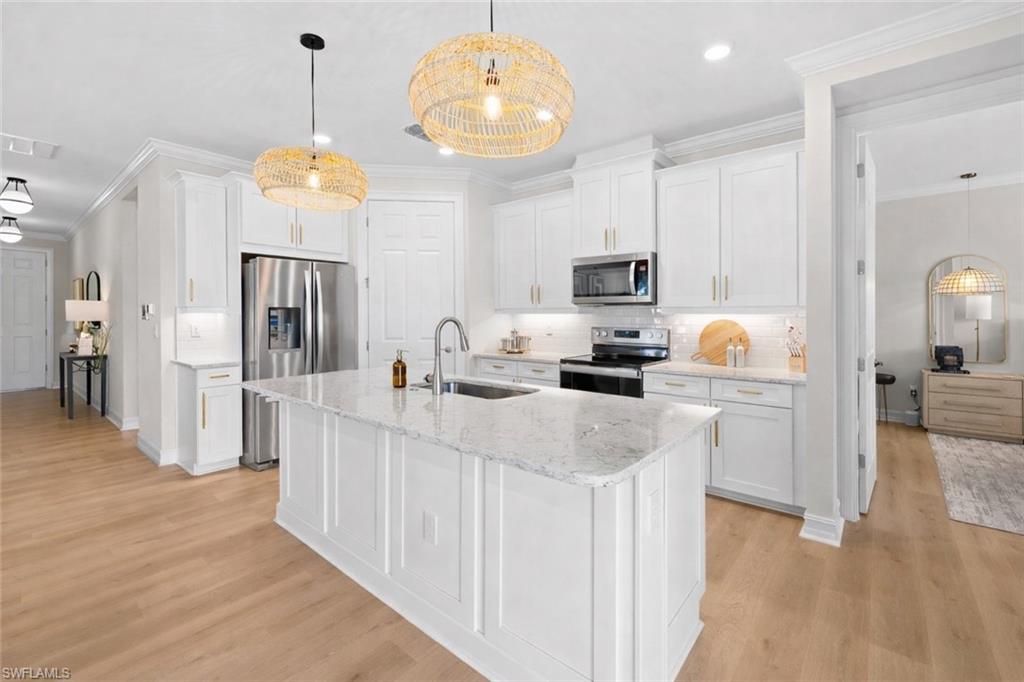 488 Polihale Way Naples, FL 34114 - Photo 19 of 49 a kitchen with stainless steel appliances a refrigerator a stove a sink dishwasher and a fireplace with wooden floor