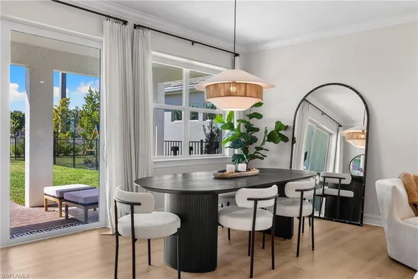 a dining room with furniture a potted plant and a chandelier