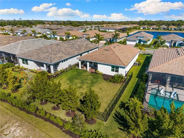 an aerial view of residential houses with outdoor space and ocean view