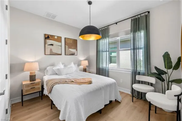 a bedroom with a bed and a potted plant