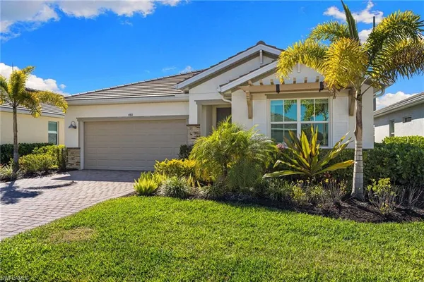 a view of a house with a small yard and a palm tree