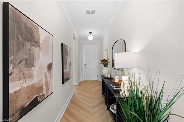 a view of a hallway with wooden floor and a bathroom view
