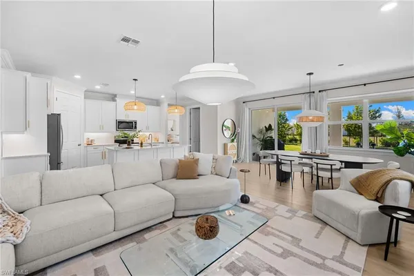 a living room with furniture kitchen and a chandelier