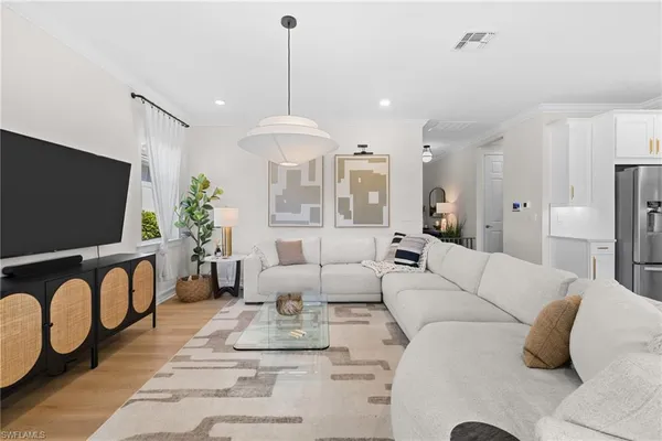 a living room with furniture a dining table and a chandelier
