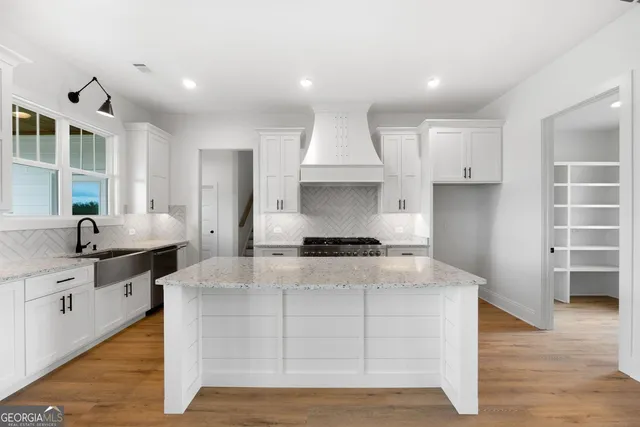 a large kitchen with stainless steel appliances granite countertop a stove a sink and a refrigerator