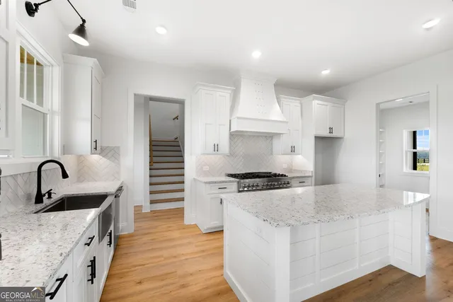 a kitchen with granite countertop a sink and a stove top oven