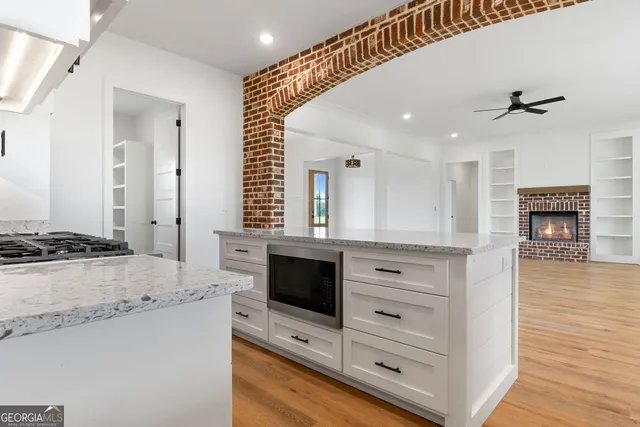 a spacious bathroom with a granite countertop sink a mirror and a bathtub