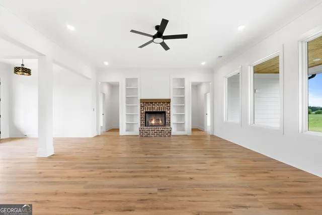 a view of an empty room with a fireplace and a window