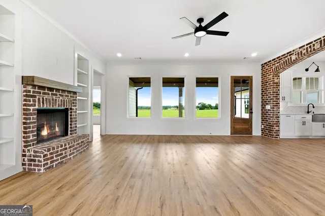 an empty room with wooden floor a fireplace and a window