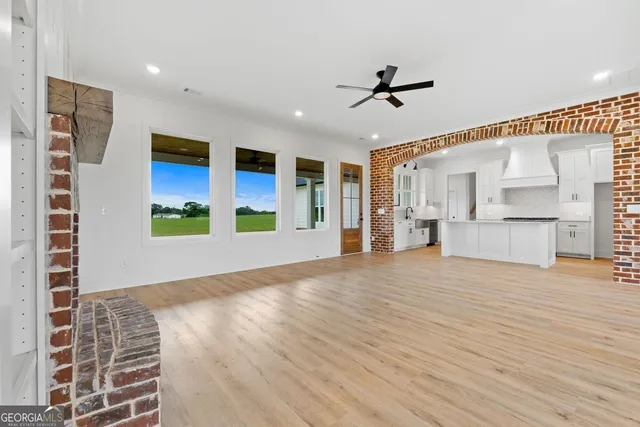 a view of a living room with furniture and a ceiling fan