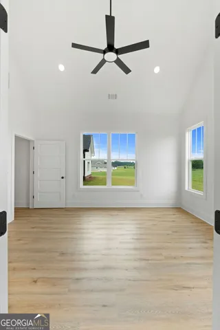 a view of a room with a window and a ceiling fan