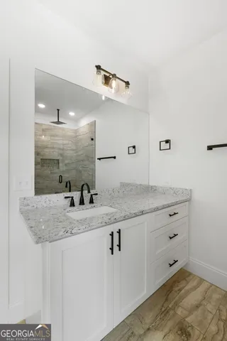 a bathroom with a granite countertop sink and a mirror