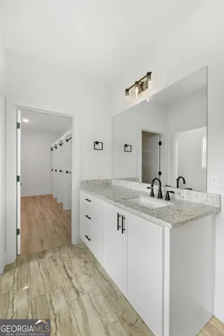 a bathroom with a granite countertop sink and a mirror