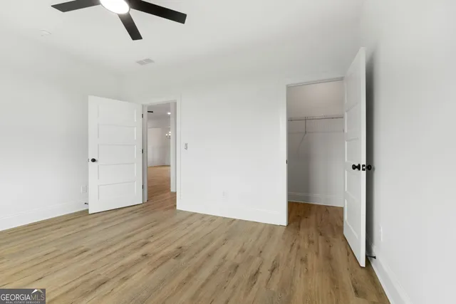 a view of empty room with wooden floor