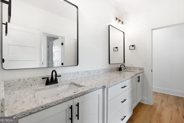 a bathroom with a granite countertop sink and a mirror