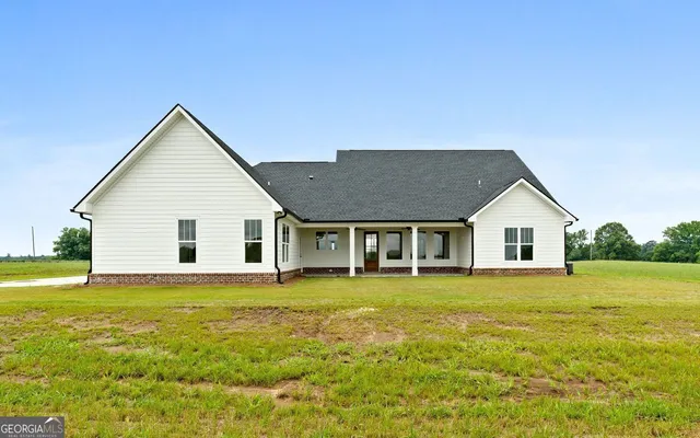 a view of house with garden and trees in the background