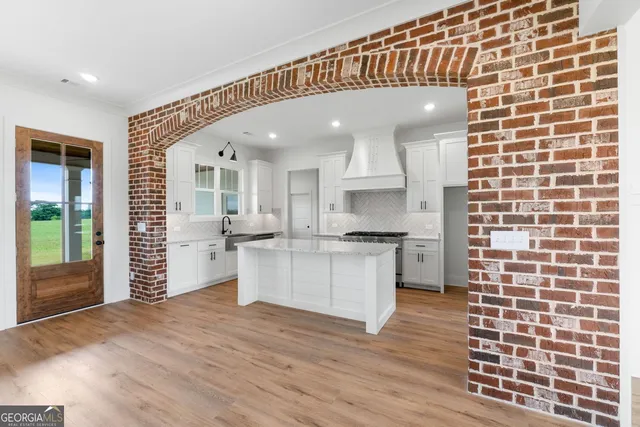 a open kitchen with white cabinets and white appliances