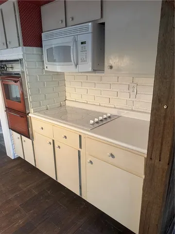 a kitchen with granite countertop white cabinets and white appliances