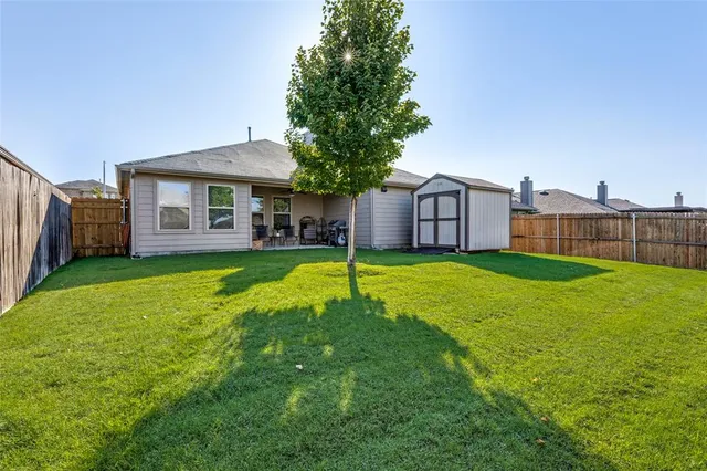 a view of a house with a big yard and a large tree